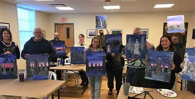 A group of several people showing their paintings from an art class
